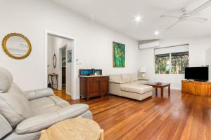 a living room with white furniture and a flat screen tv at Stockton Coastal Escape in Stockton