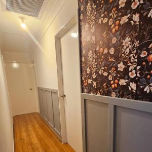 a hallway with a large floral painting on the wall at Homestay in Coogee