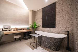 a bathroom with a tub and a desk and a sink at 대구 이스턴호텔 라이온즈파크점 in Daegu +157 photos