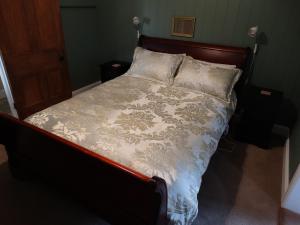 un letto con testiera e cuscini in legno di Loughmore House a Eukey