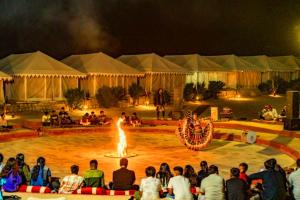 a group of people watching a fire show in a circus at Marwar Desert Camp Sam Jaisalmer in Sām