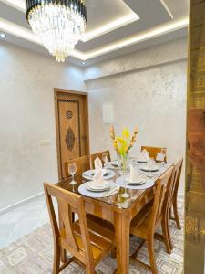 a dining room with a table with chairs and a chandelier at Dar marhaba in Tangier