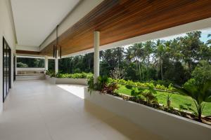 an open hallway with a large window with plants at Mandalore Villas Ubud - Adults Only in Ubud