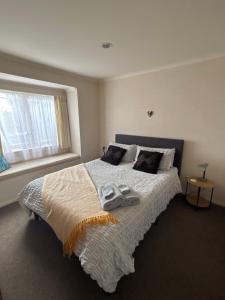 a bedroom with a large bed with two shoes on it at Sunsets over Unsworth in Auckland