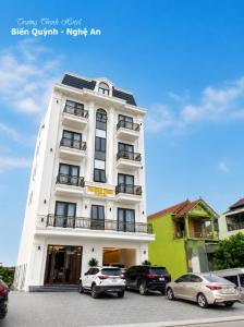 a white building with cars parked in front of it at TRƯỜNG THỊNH Hotel in Hòn Tru