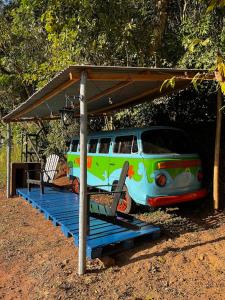 a colorful van parked under a shed with a porch at Kombi do Scooby-Doo in Mairiporã +15 photos