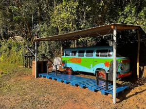a van parked under a shed with a roof at Kombi do Scooby-Doo in Mairiporã