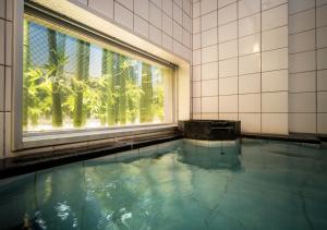 a swimming pool with a window in a building at Super Hotel Yokkaichi Route 1 in Yokkaichi