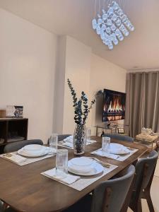 a dining room table with plates and a vase with flowers at California style Resident in Iloilo City