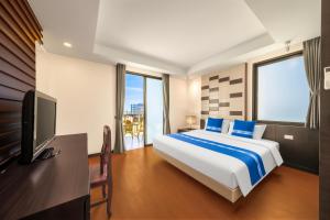 a hotel room with a bed and a television at Tycoon Holiday Hotel in Pattaya +43 photos