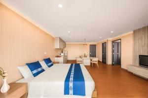 a large bedroom with a large bed and a living room at Tycoon Holiday Hotel in Pattaya