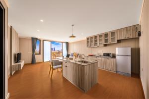a kitchen with a refrigerator and a table in it at Tycoon Holiday Hotel in Pattaya