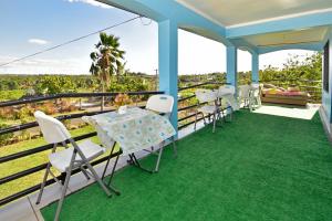 a room with a table and chairs on a balcony at Save's Homestay in Nadi