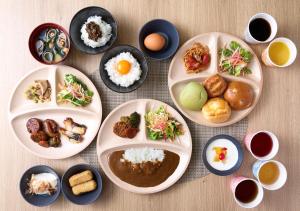 a table with plates of food and bowls of food at Super Hotel Yokkaichi Route 1 in Yokkaichi