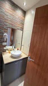 a bathroom with a sink and a wooden door at Base de los Andes 4 in Maipú +16 photos