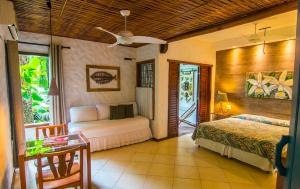 a bedroom with a bed and a table in a room at Pousada Luz Do Sol in Porto Seguro