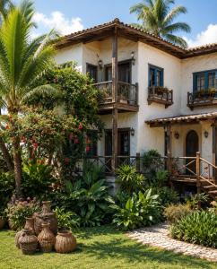 a house with a palm tree in front of it at Pousada Luz Do Sol in Porto Seguro