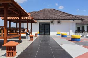 a white building with a black door and some benches at Aisyi Tower Klaten in Klaten