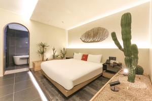 a bedroom with a white bed and a cactus at 대구 이스턴호텔 라이온즈파크점 in Daegu