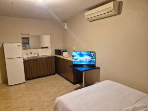 a room with a bed and a kitchen with a refrigerator at Kaban Power 11 in Marayong