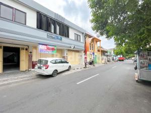 a white car parked on the side of a street at Blessings Homestay RedPartner near Stasiun Kediri in Kediri