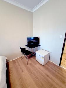 a bedroom with a bed and a desk with a keyboard at Kaban Power 11 in Marayong