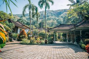 a courtyard at a resort with palm trees at DW Jungle Resort - Candidasa in Candidasa