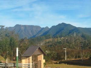 a house with a view of mountains in the background at Pousada Bella Montanha in Lauro Müller