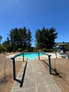 a swimming pool with a ramp and trees in the background at Campo Yumbel in Yumbel