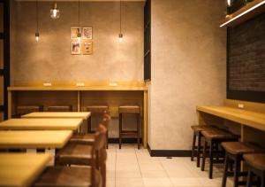 a dining room with tables and stools in a restaurant at Super Hotel Yokkaichi Route 1 in Yokkaichi