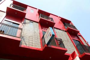 a red building with windows and a sign on it at Snow White Residence near Grogol Mitra RedDoorz in Jakarta