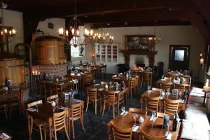 a restaurant with wooden tables and chairs in a room at De Hemel De Kracht van Ambacht in Nijmegen