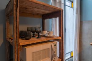a wooden shelf above a microwave with glasses on it at La Piamonte 1903 in Azcuénaga +22 photos