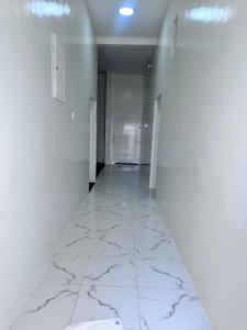 an empty hallway with white walls and marble floors at كوس الاشخرة in Al Sharqiyah