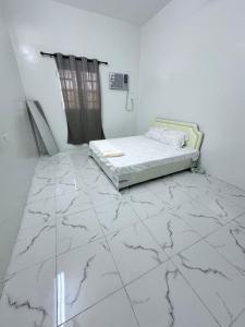 a bedroom with a bed on a marble floor at كوس الاشخرة in Al Sharqiyah