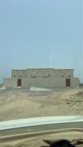 a building in the middle of a dirt field at كوس الاشخرة in Al Sharqiyah