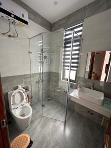 a bathroom with a shower and a toilet and a sink at House 1994 in Xuan An +17 photos