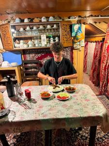 a man sitting at a table with plates of food at Pana 4 Boat House in Srinagar +43 photos