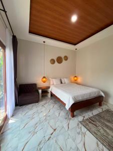a bedroom with a king sized bed and a couch at Villa Bumi Detani in Selabintana +15 photos