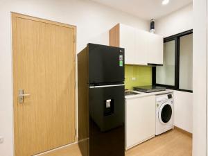 a kitchen with a black refrigerator and a washer at Urban Nest - Cầu Giấy in Hanoi