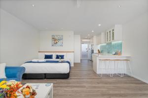 a bedroom with a king sized bed and a kitchen at Seaview Studio Apartment - Beachfront with Heated Pool in Whitianga +12 photos