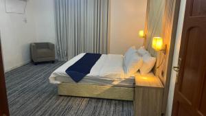 a hotel room with a bed and a chair at انهار للشقق المخدومة in Taif
