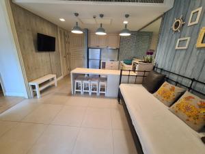 a living room with a couch and a kitchen at Marrakesh Residence HuaHin BunkBed Family Room in Hua Hin