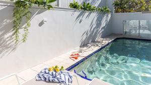 a swimming pool with a bunch of fruit on a towel at White Sails 4 - Luxury Coastal Retreat with Pool & Views - Holiday Yamba in Yamba