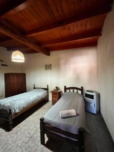 a bedroom with two beds and a wooden ceiling at Departamento Ayllu IV in Tilcara +9 photos