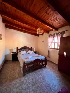 a bedroom with a bed and a wooden ceiling at Departamento Ayllu IV in Tilcara