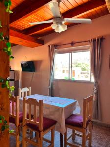 a dining room table with chairs and a ceiling fan at Departamento Ayllu IV in Tilcara