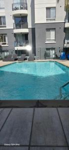 a large blue swimming pool in front of a building at 1-Bedroom Apartment near ALX Airport and the Ocean in Los Angeles