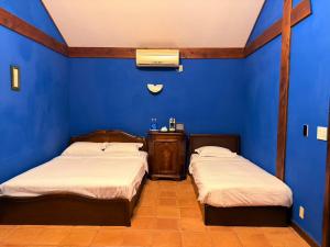two beds in a room with a blue wall at クースクース in Fujikawaguchiko +54 photos