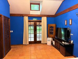 a living room with blue walls and a tv at クースクース in Fujikawaguchiko